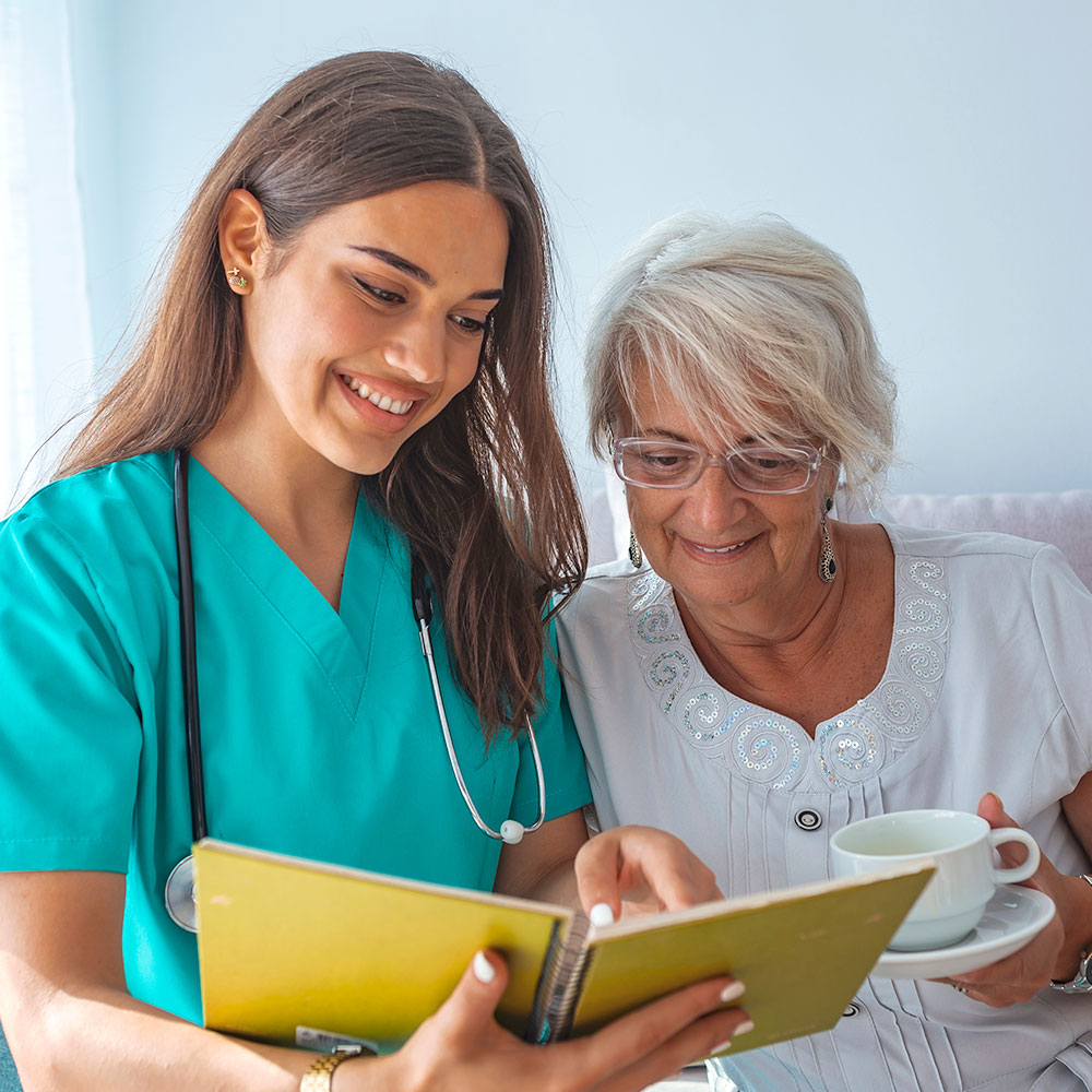 Nurse reading to elderly patient